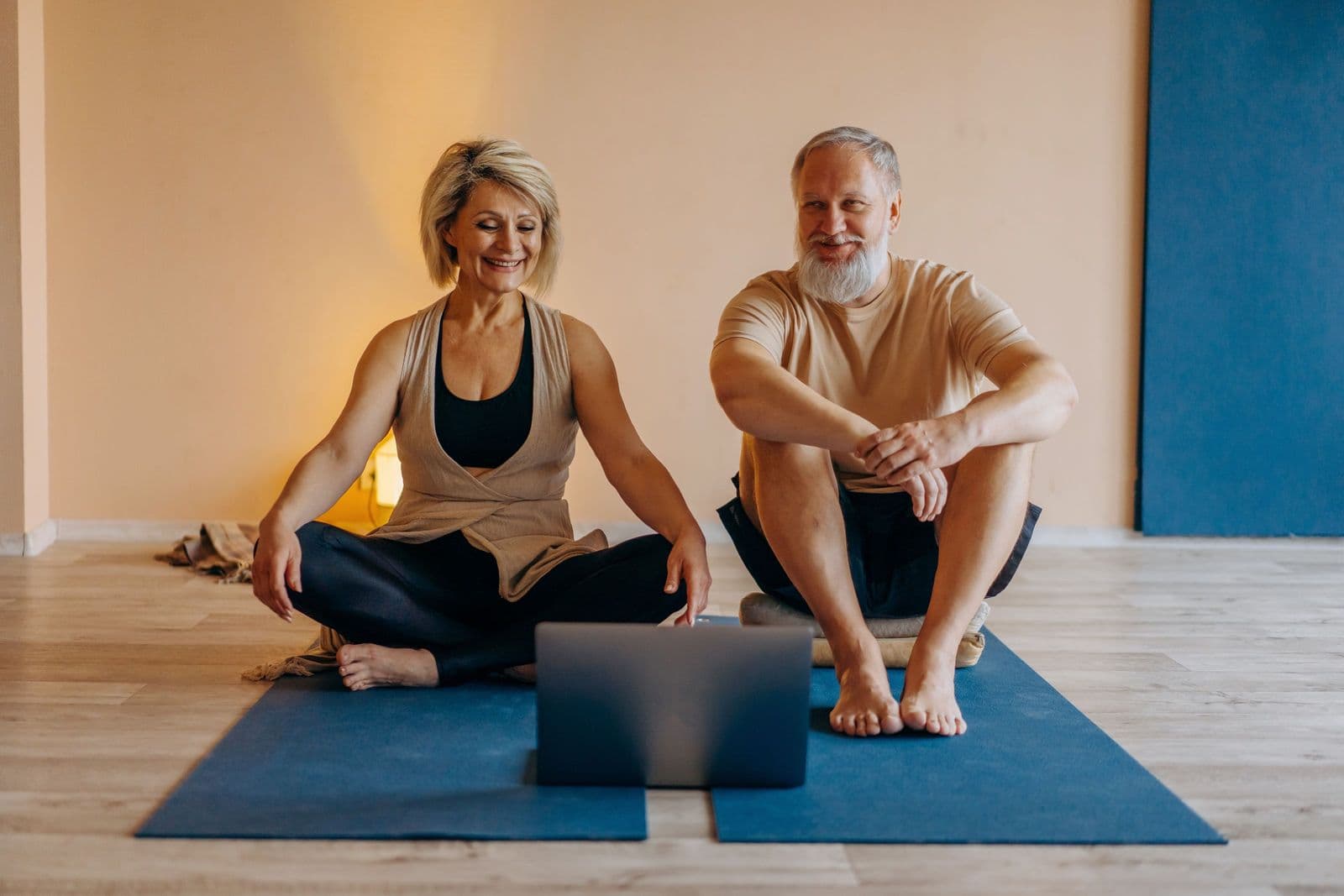 Two patients following their exercise plan together at home, laptop open in front of them